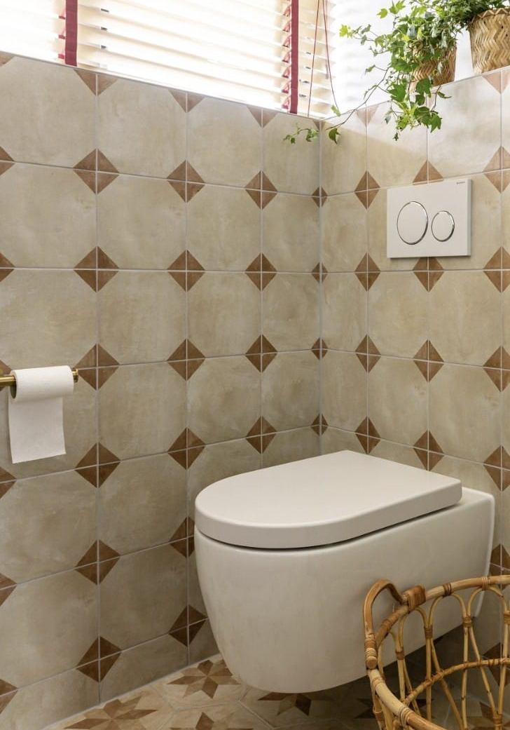 Wit hangend toilet tegen een lichtbruine tegeltjeswand